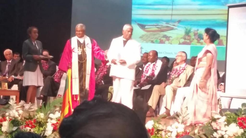 group of people on a stage making a presentation, this time two people are in the center with a plaque